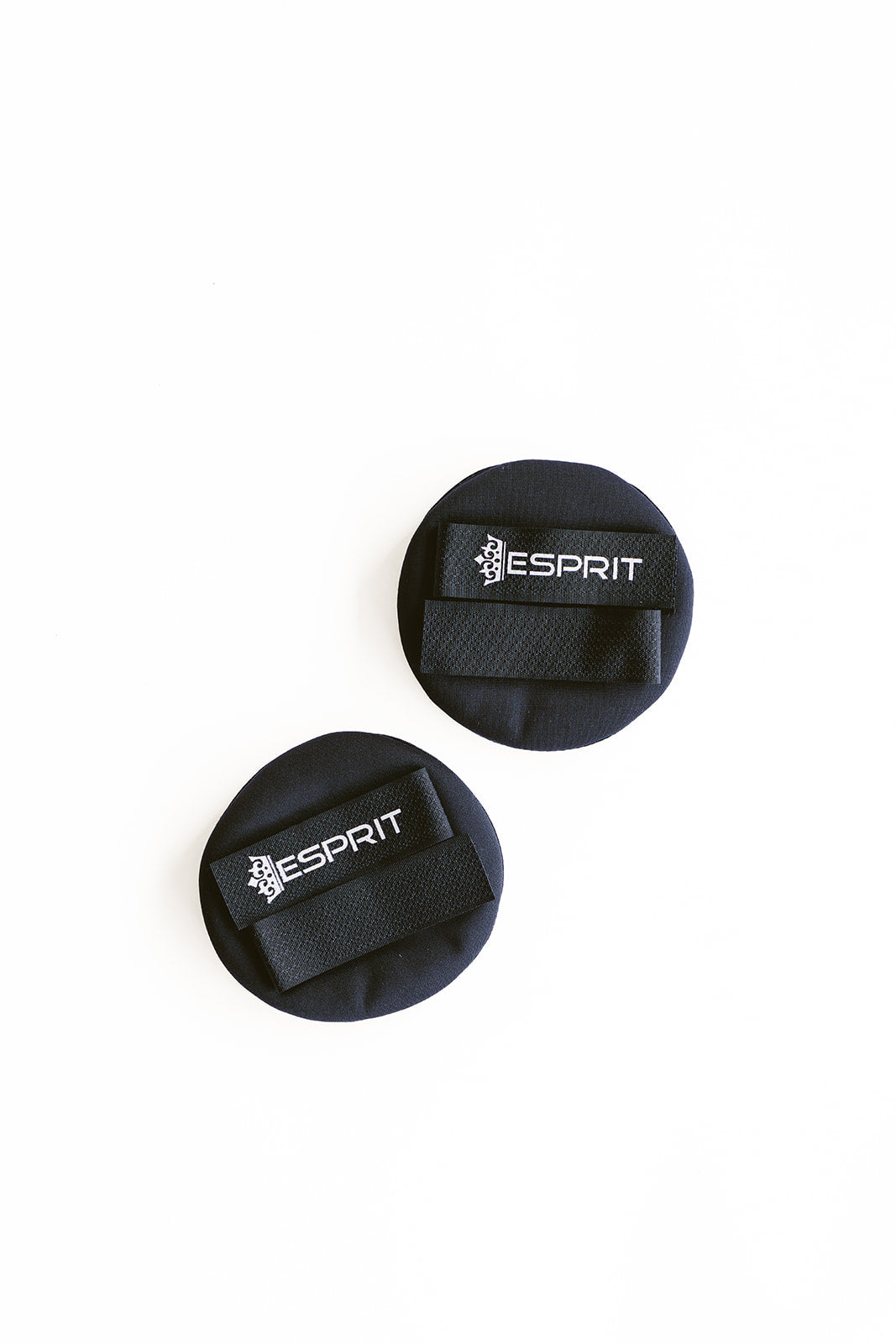 Pair of black Esprit helmet earmuffs with Velcro straps on a white background