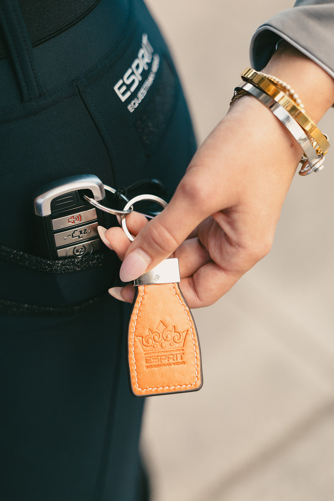 Close-up of the Esprit crown stamped on the leather stirrup key chain