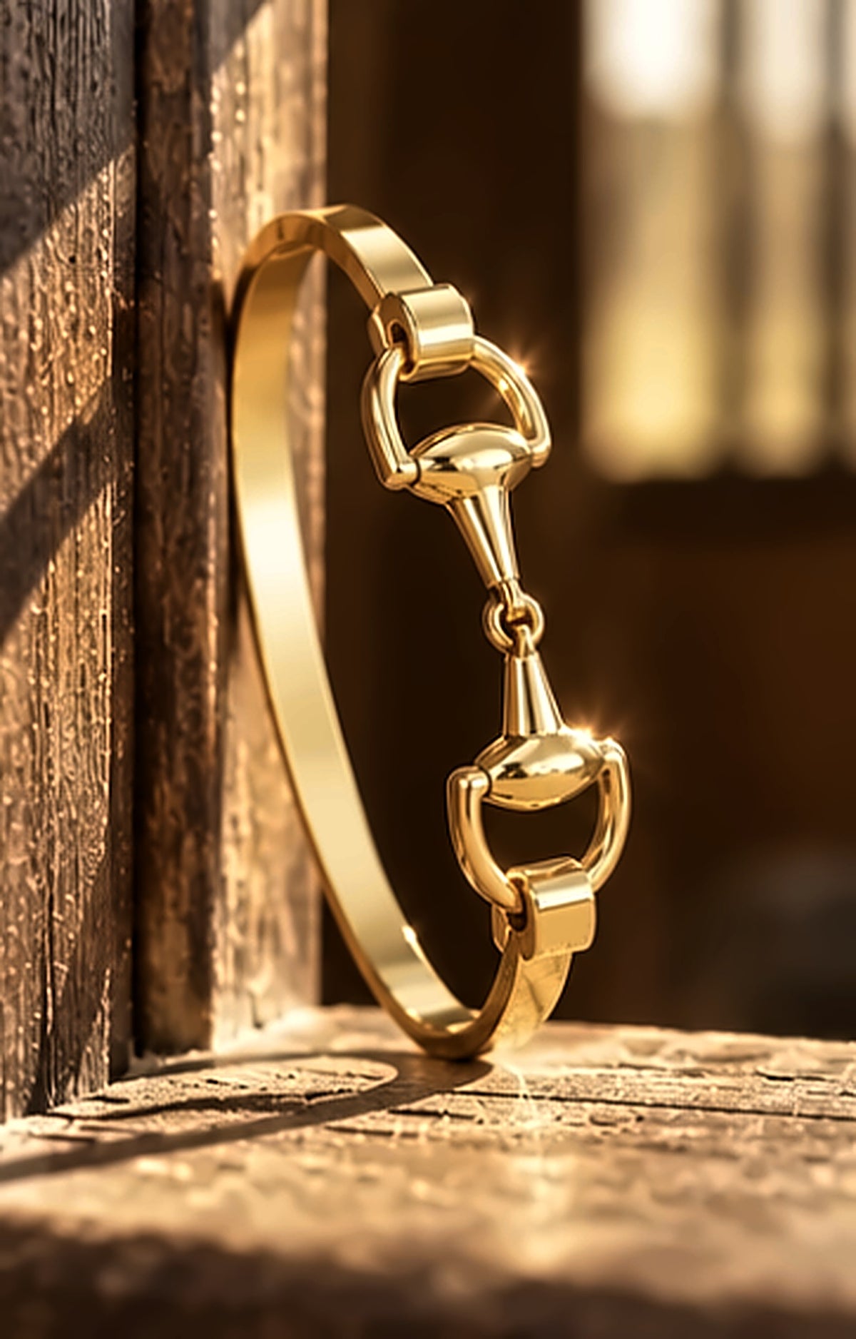 Gold snaffle bit bracelet standing upright on a wooden barn ledge
